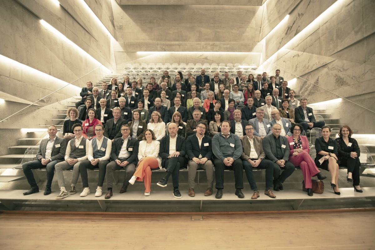 In dem Konzerthaus sitzen viele Menschen auf Stühlen