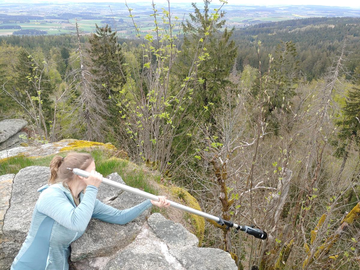 Eine Frau mit einem verlängerten Scanner, der über die Burgmauer hinausgeht