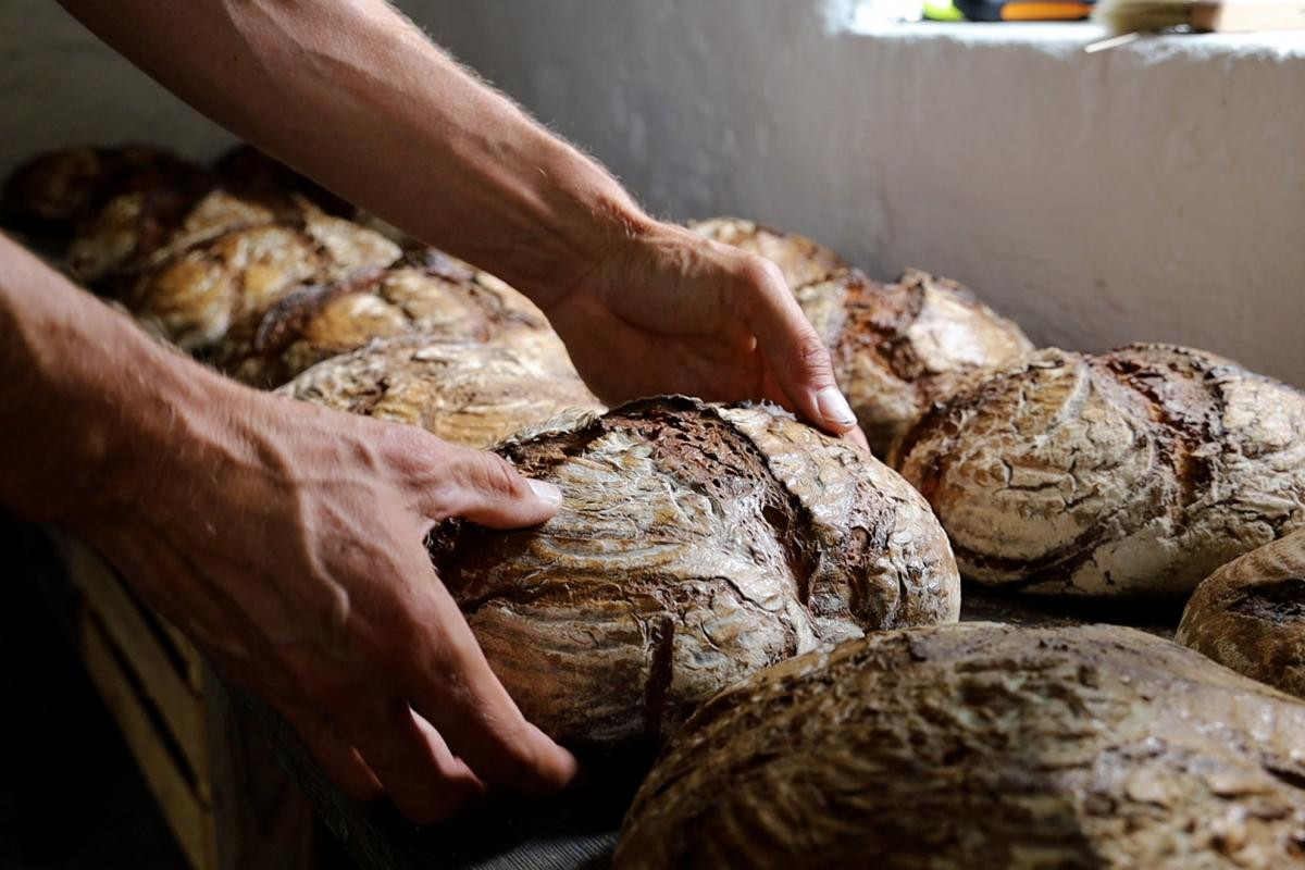 Ein Laib Brot wird auf andere Brote gelegt.