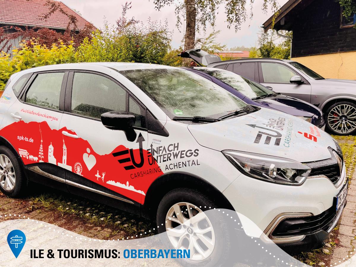 Ein Auto mit Folierung "Einfach unterwegs - Carsharing Achental" steht auf einem Parkplatz