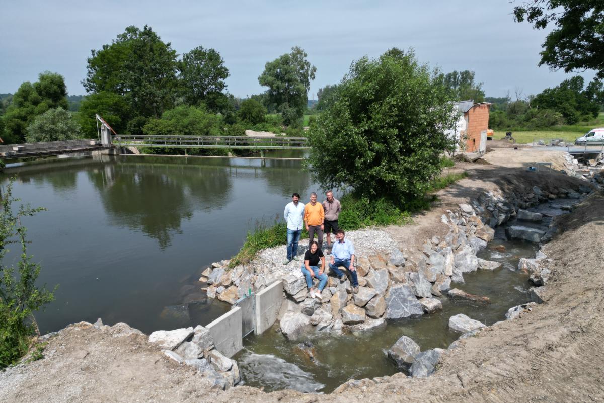 Blick auf die Mindel, das neue Umgehungsgerinne und die Menschen bei der Inbetriebnahme.