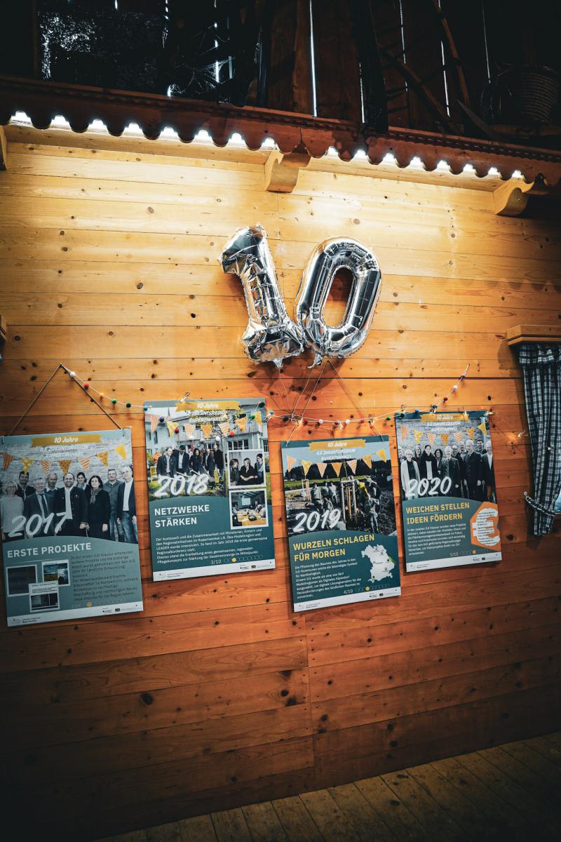 Für die Veranstaltung würde eine Holzwand mit Bildern zum 10 jährigen Jubiläum geschmückt.