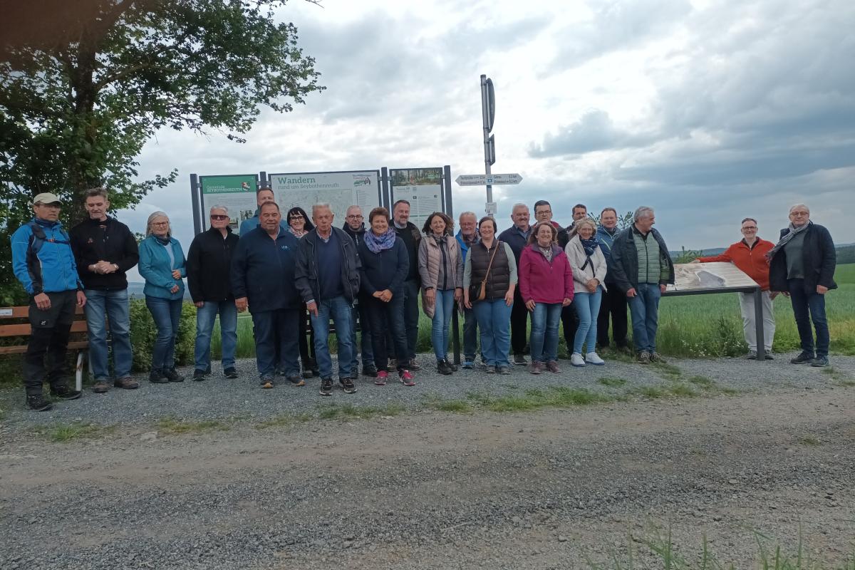 Eine Gruppe Menschen steht vor Infotafeln