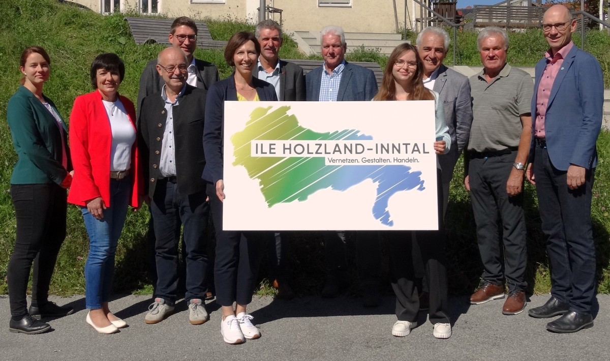 Mehrere Personen halten ein Schild mit dem ILE-Logo in Händen