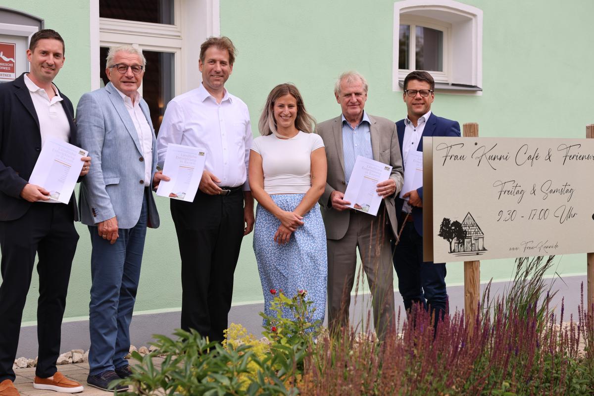 Sechs Personen stehen vor dem Café Frau Kunni (v.l.): Ralf Kunzmann, Erster Bürgermeister von Gräfenberg, Lothar Winkler, Leiter des ALE, Dr. Hermann Ulm, Landrat Forchheim, Julia Buttler, Betreiberin des Cafés, Bruno Kellner, stellvertr. Landrat Bamberg, ALE-Abteilungsleiter Thomas Müller