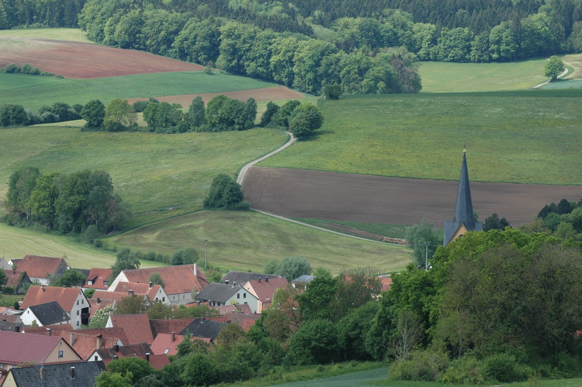 Ein kleines Dorf in hügeliger Landschaft