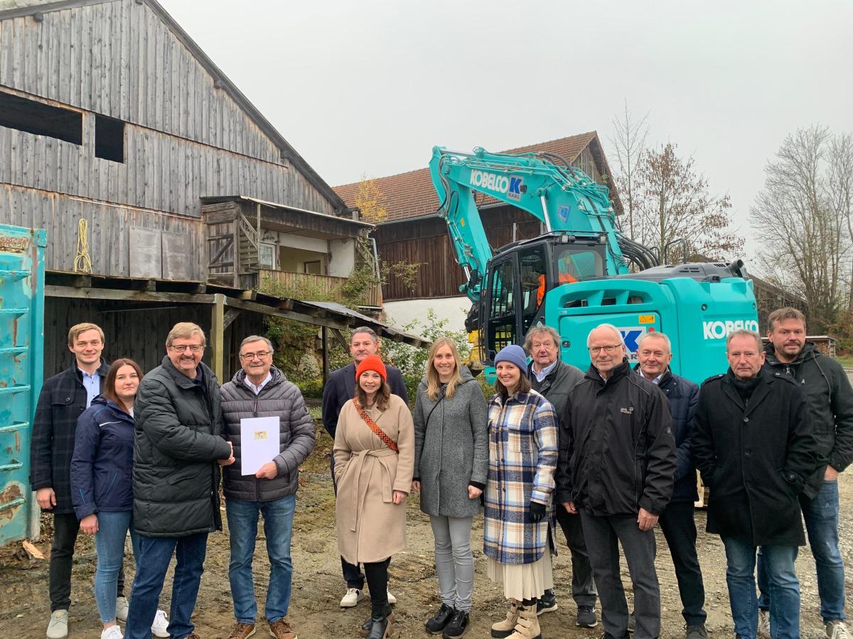 Neun Herren und vier Damen stehen nebeneinander vor dem leerstehenden Gutshof in Innernzell. Hinter ihnen befindet sich ein Bagger.