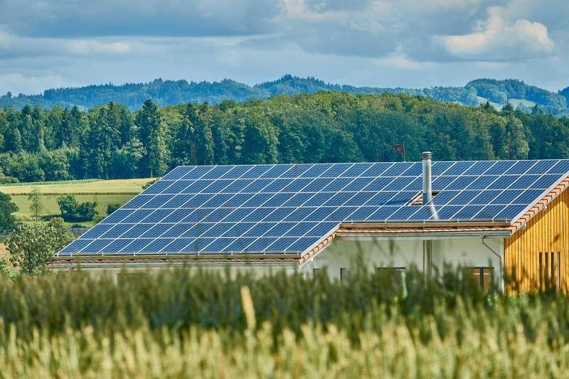 Haus mit Solaranlage, im Hintergrund Berge