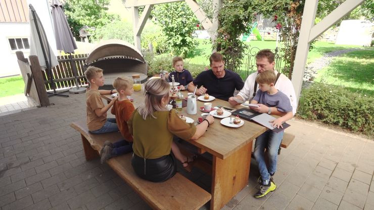 Familie sitzt am Terrassentisch