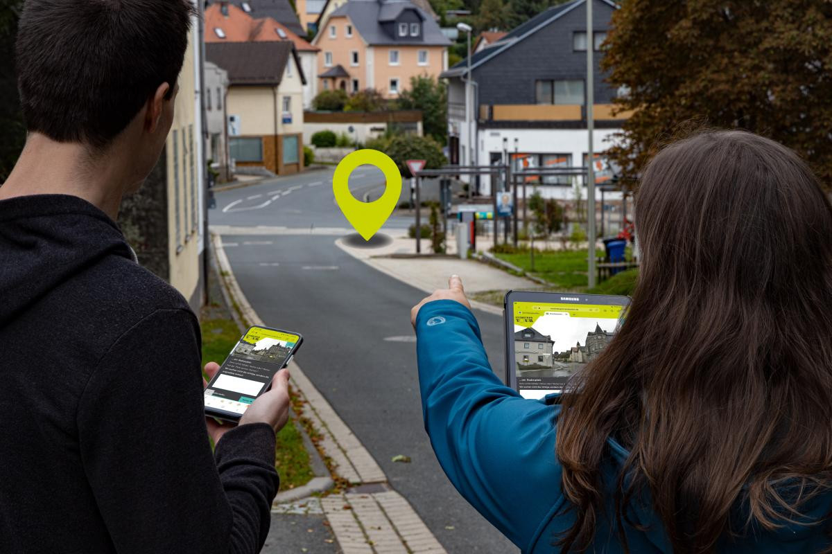 Zwei Jugendliche entdecken ihr Dorf mit dem Smartphone.