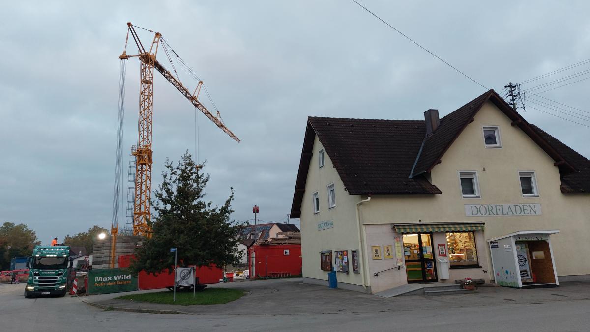 Im Vordergrund steht ein Gebäude, im Hintergrund ein Kran.