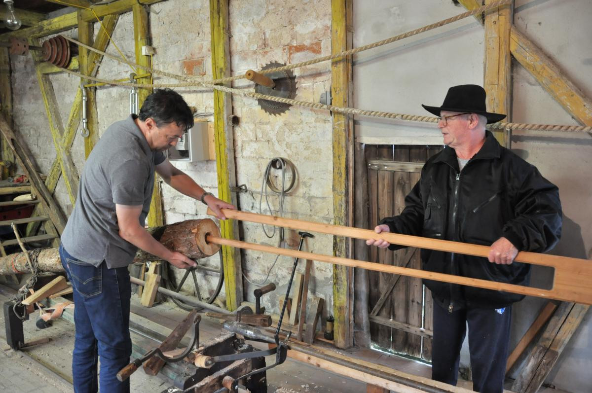 Zwei Männer arbeiten an den Geräten der alten Röhrenbohrerei