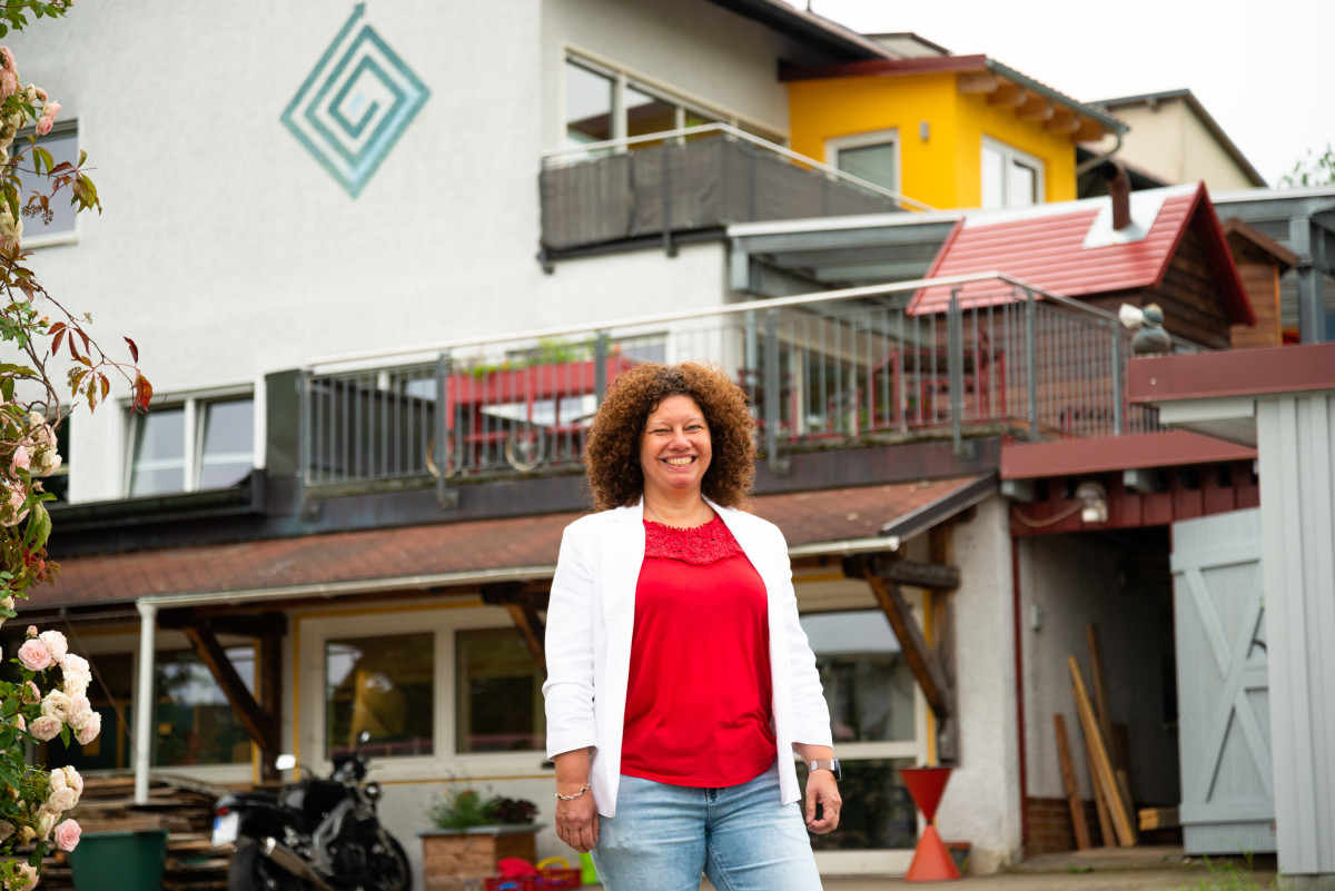 Halbtotale von Melanie Bruckner, die vor dem Gebäude des Reha-Zentrums in Waldthurn steht.